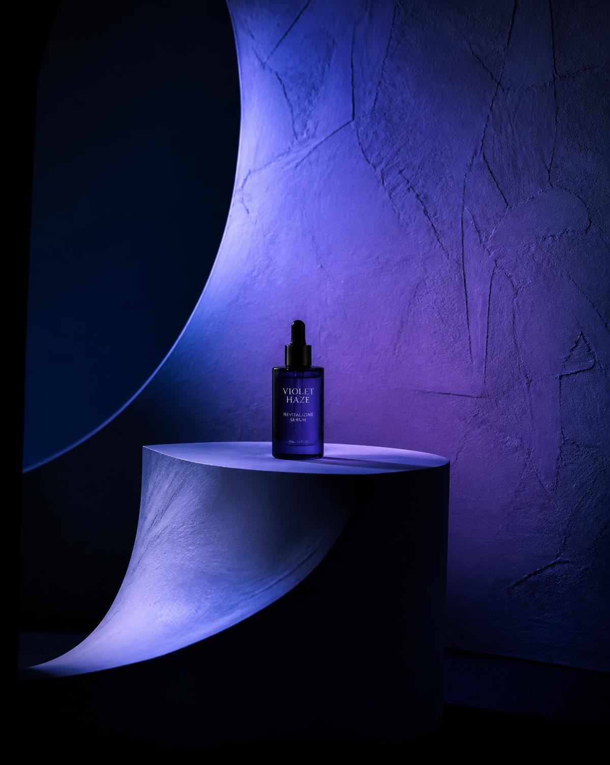 Beauty product on a sculpted plinth lit with indigo gels on a studio set